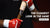 A close-up of a baseball player holding a pine tar bat with a clear focus on the Tater logo. The player wears red and white batting gloves.