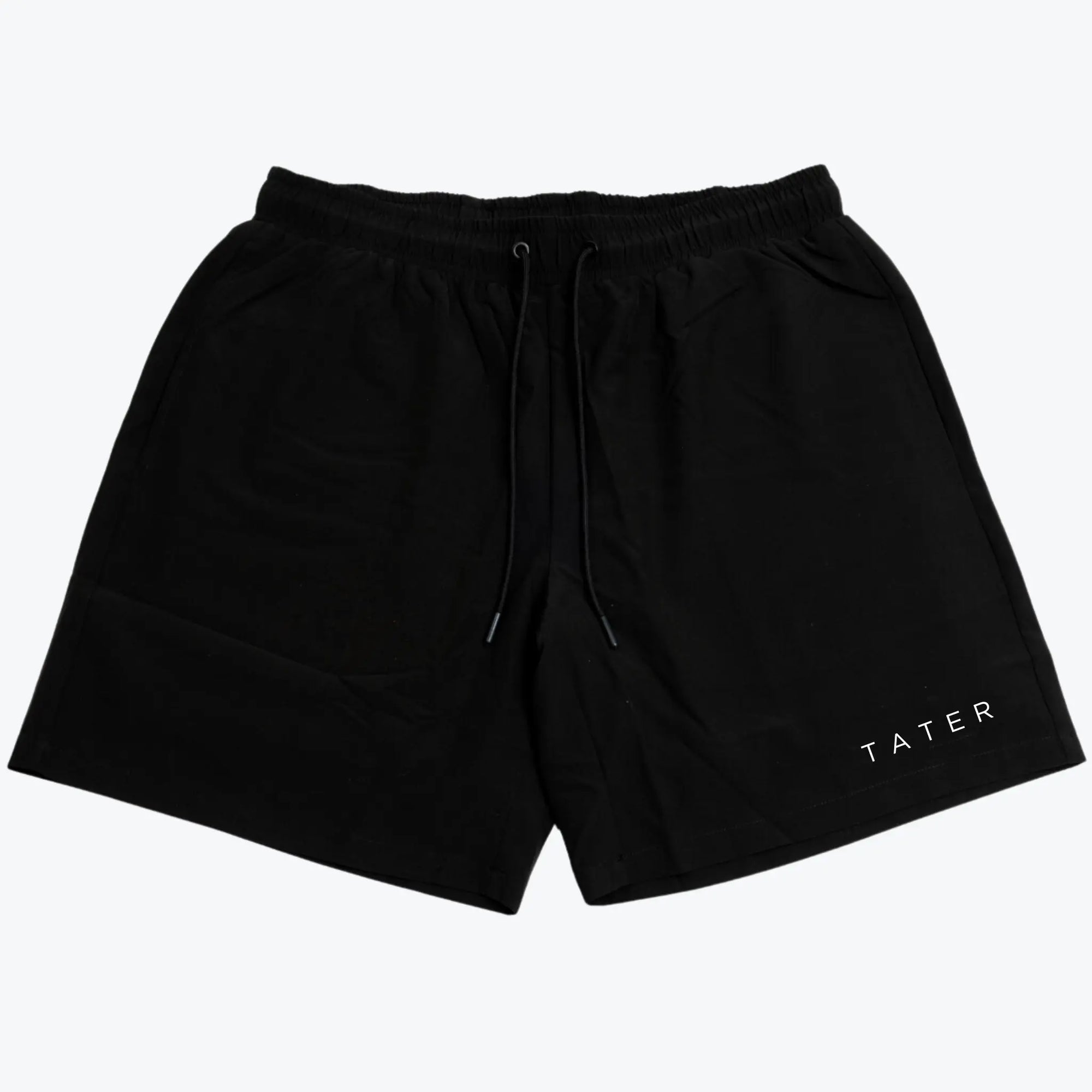The image displays a pair of black athletic workout shorts that feature a white "TATER" logo on the left leg. These shorts are likely designed for comfort and performance, suitable for baseball practice or general athletic activities. The shorts seem to have a drawstring for adjustable fit and might be compression lined, offering additional support and mobility for athletes. The black color is classic, making them versatile for pairing with other athletic wear.
