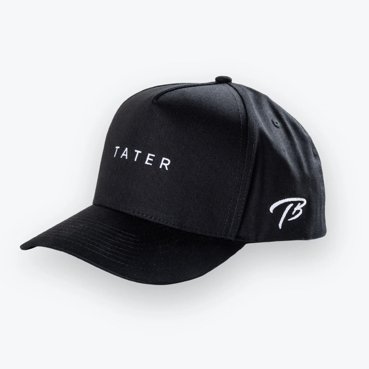 The image features a black snapback hat with the word &quot;TATER&quot; embroidered in white on the front, signifying the Tater Baseball brand. The side of the cap also has the Tater Baseball logo, which appears to be a stylized &quot;TB&quot; in white thread. The hat&#39;s design is minimalistic and contemporary, likely appealing to a wide range of customers, both within the baseball community and those interested in casual athletic wear.