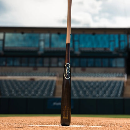 Tater Baseball's top-rated maple wood bat for hitters, standing at home plate in an empty baseball field, a preferred choice for players seeking alternatives to Louisville Slugger.