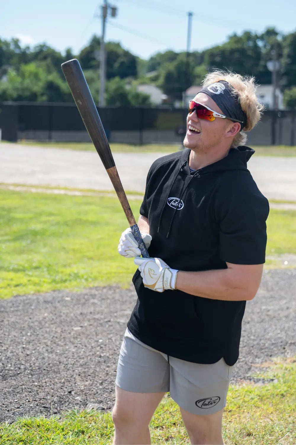Benjamin Huber laughing while standing on the on deck cricle of Municipal Stadium.